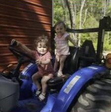 Two of the kids sat up on the tractor