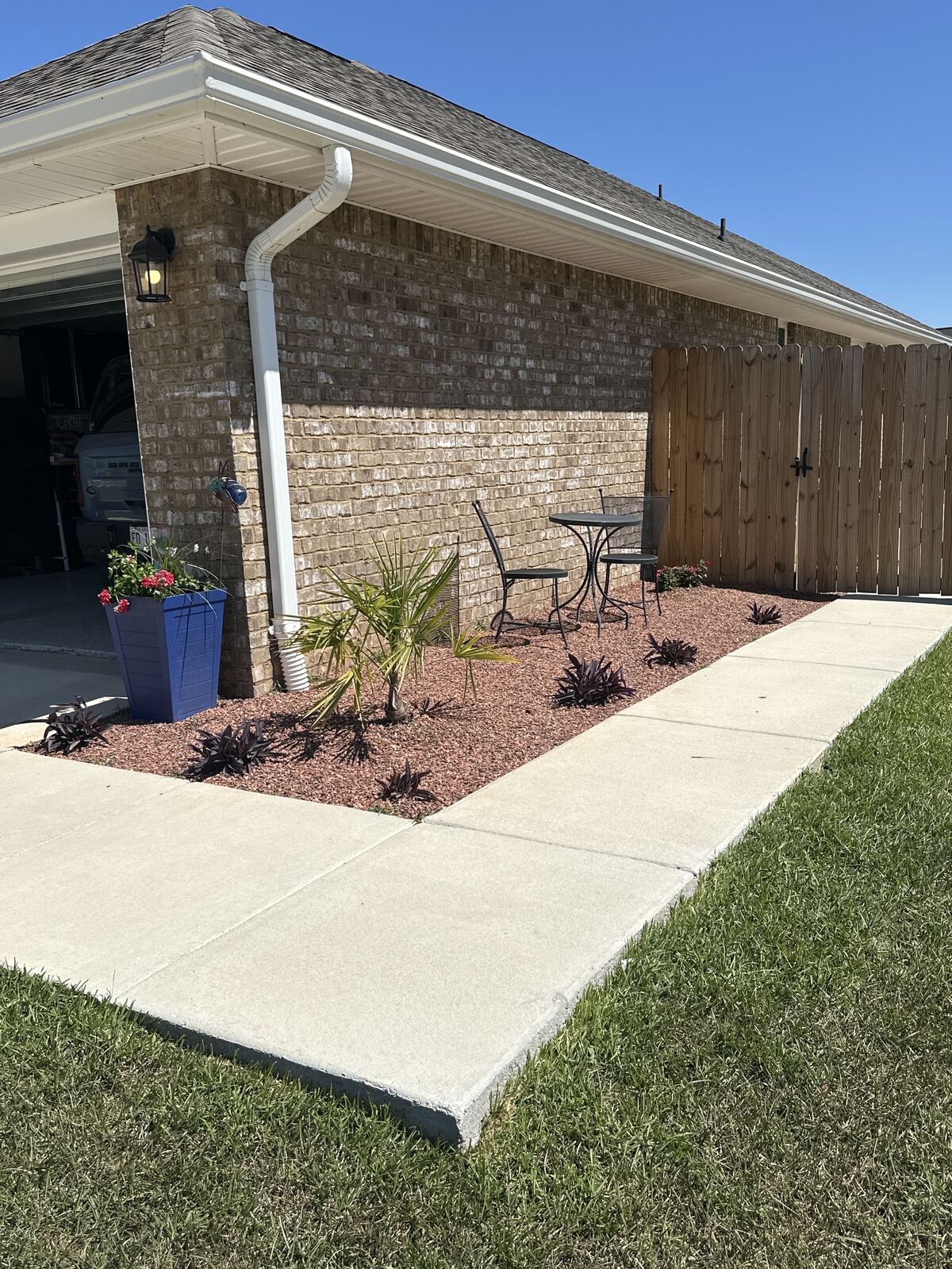 Planted bed running alongside a new concrete walkway
